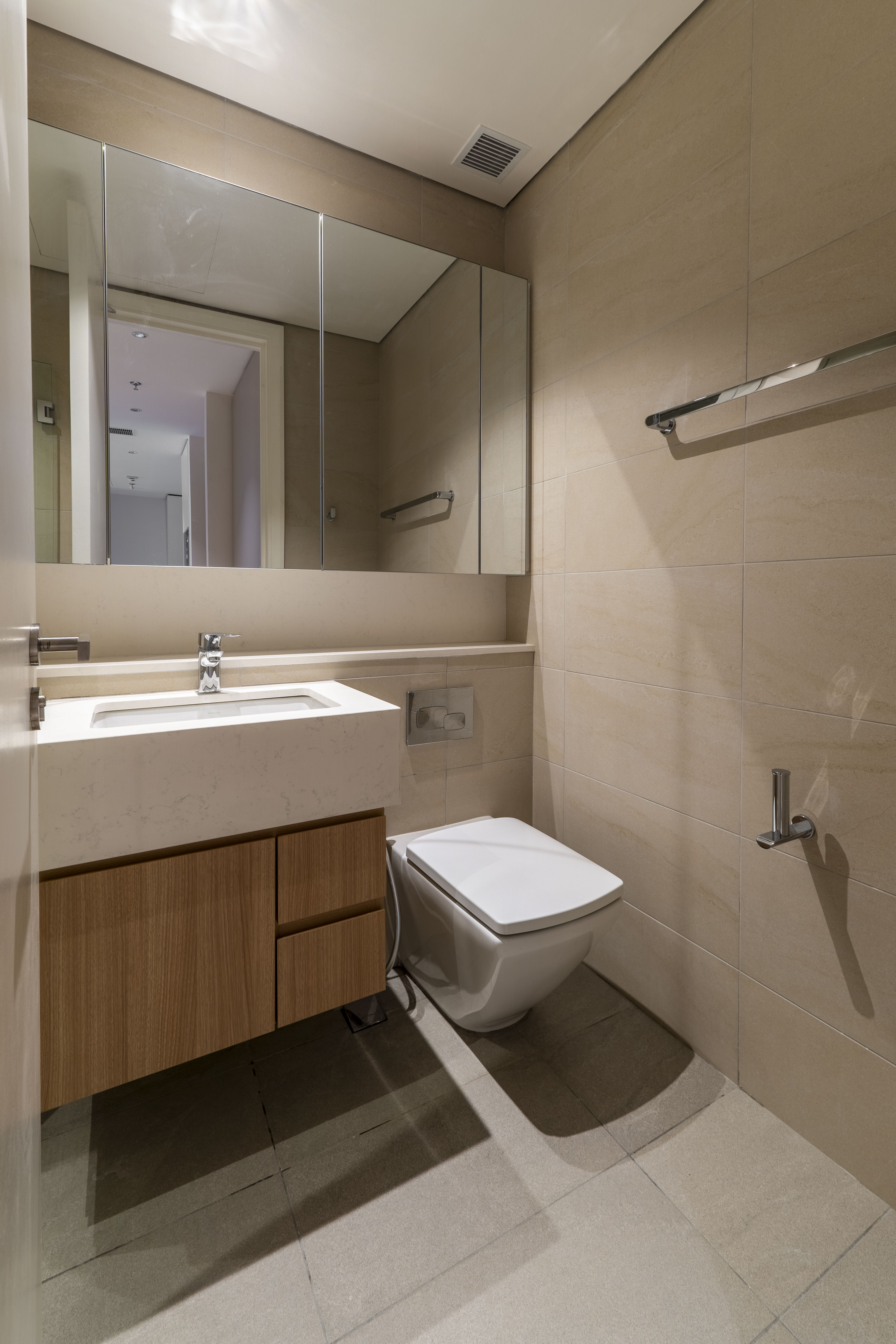 Bathroom with timber vanity, mirrored cabinet and neutral tiles at TRX Residence, Unit 01