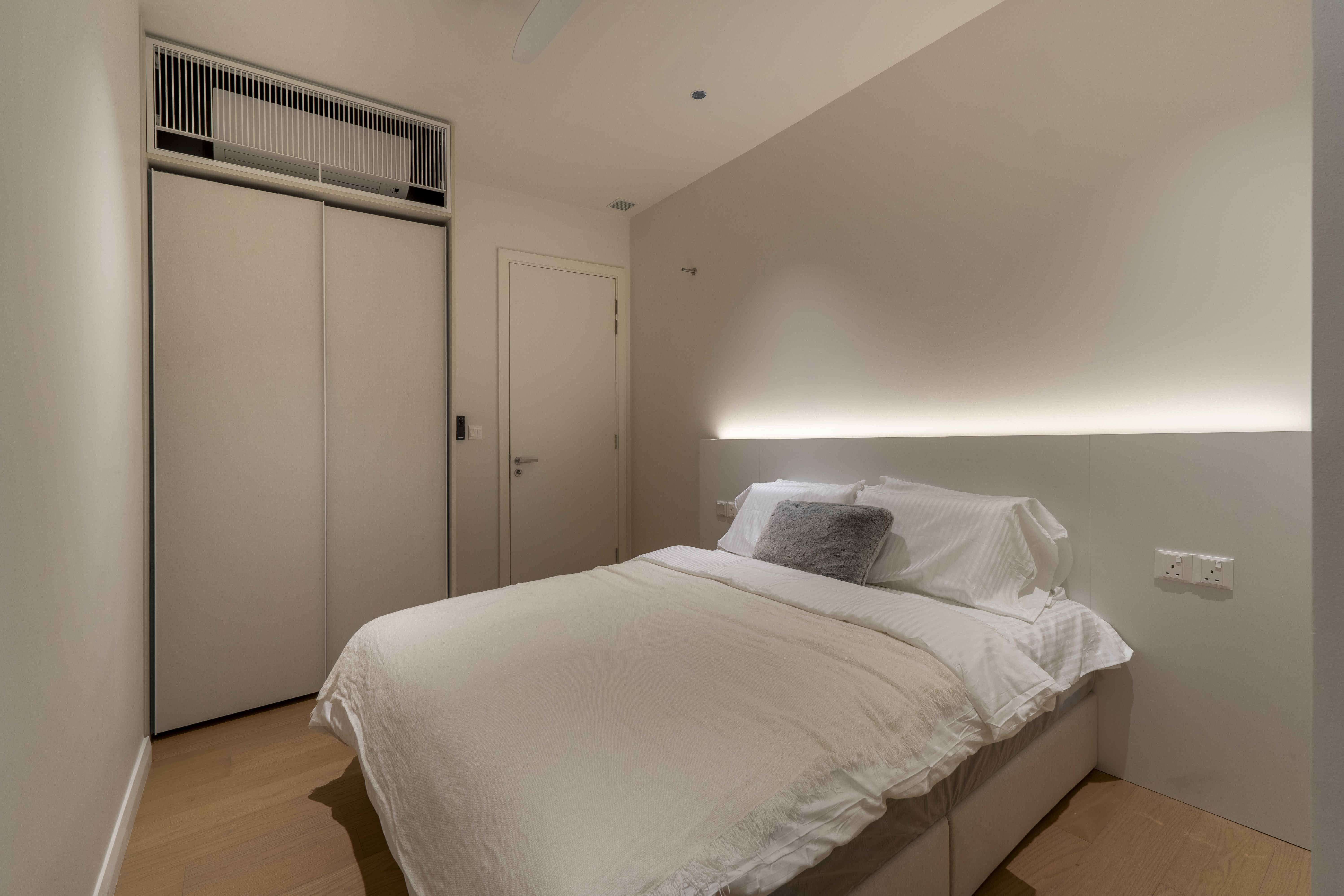 Bedroom with white bedding, built-in wardrobe and concealed lighting at TRX Residence, Unit 01