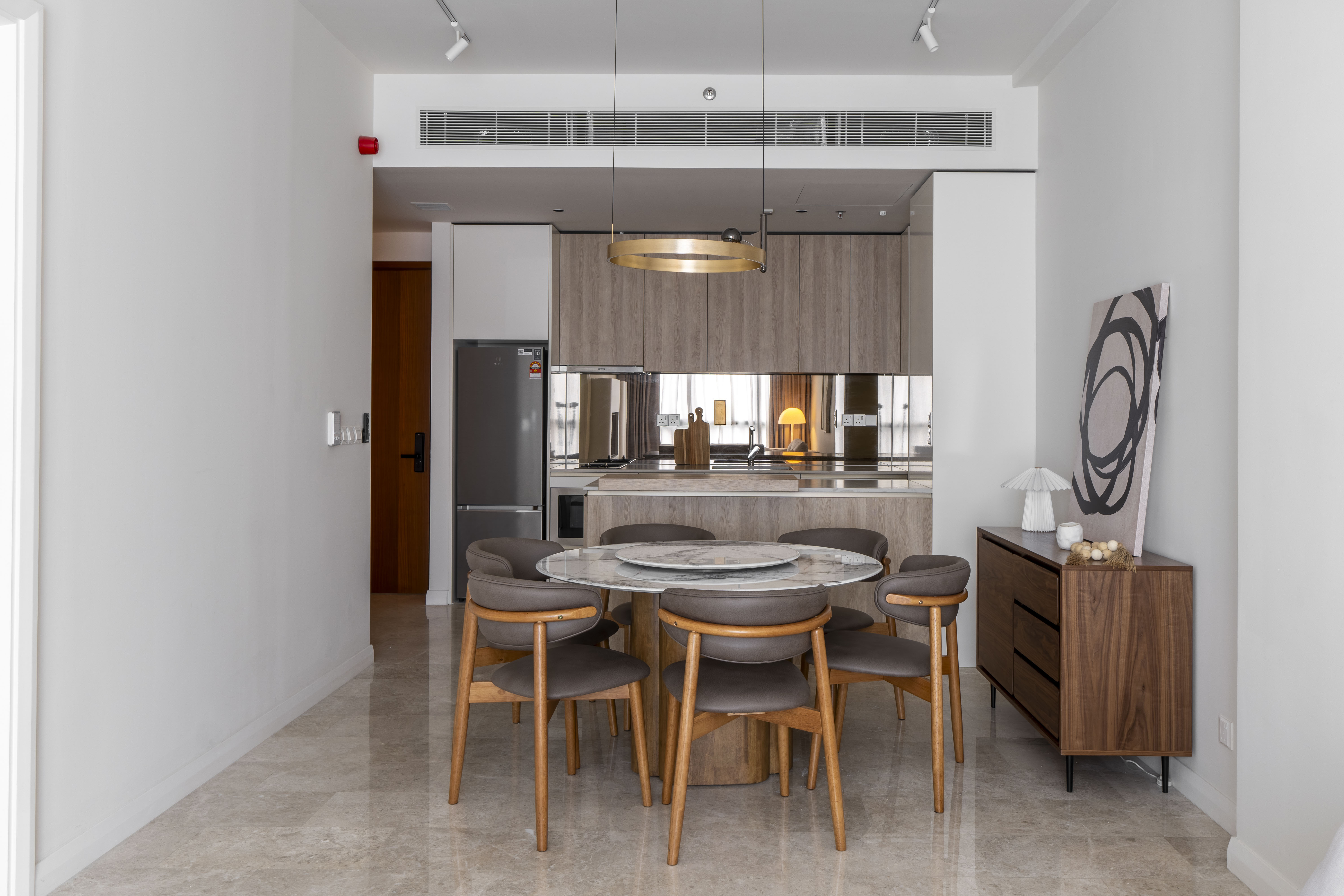 Dining area with timber kitchen cabinetry and a mirrored splashback at TRX Residence, Unit 01