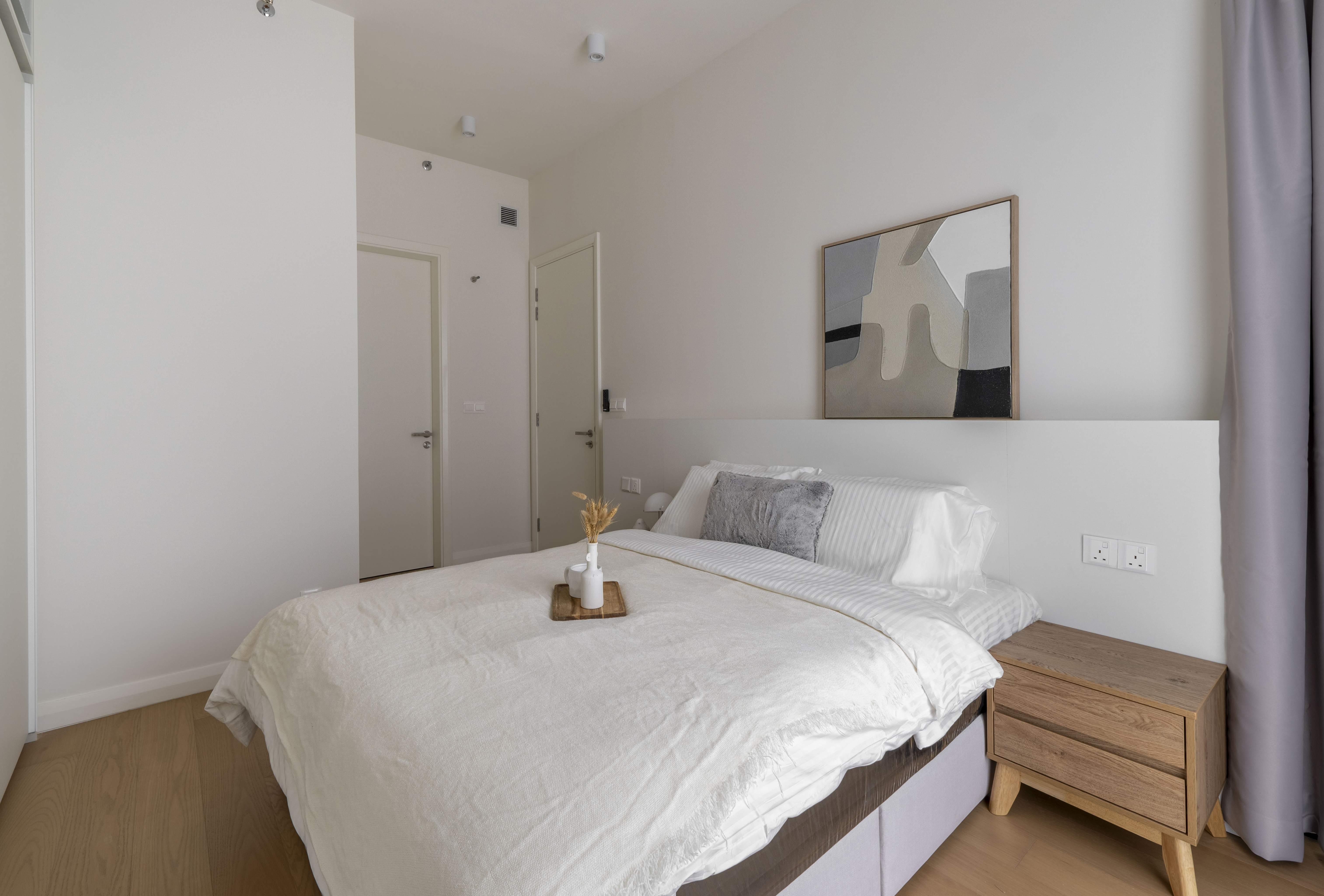 Bedroom with abstract artwork and timber bedside cabinet at TRX Residence, Unit 01