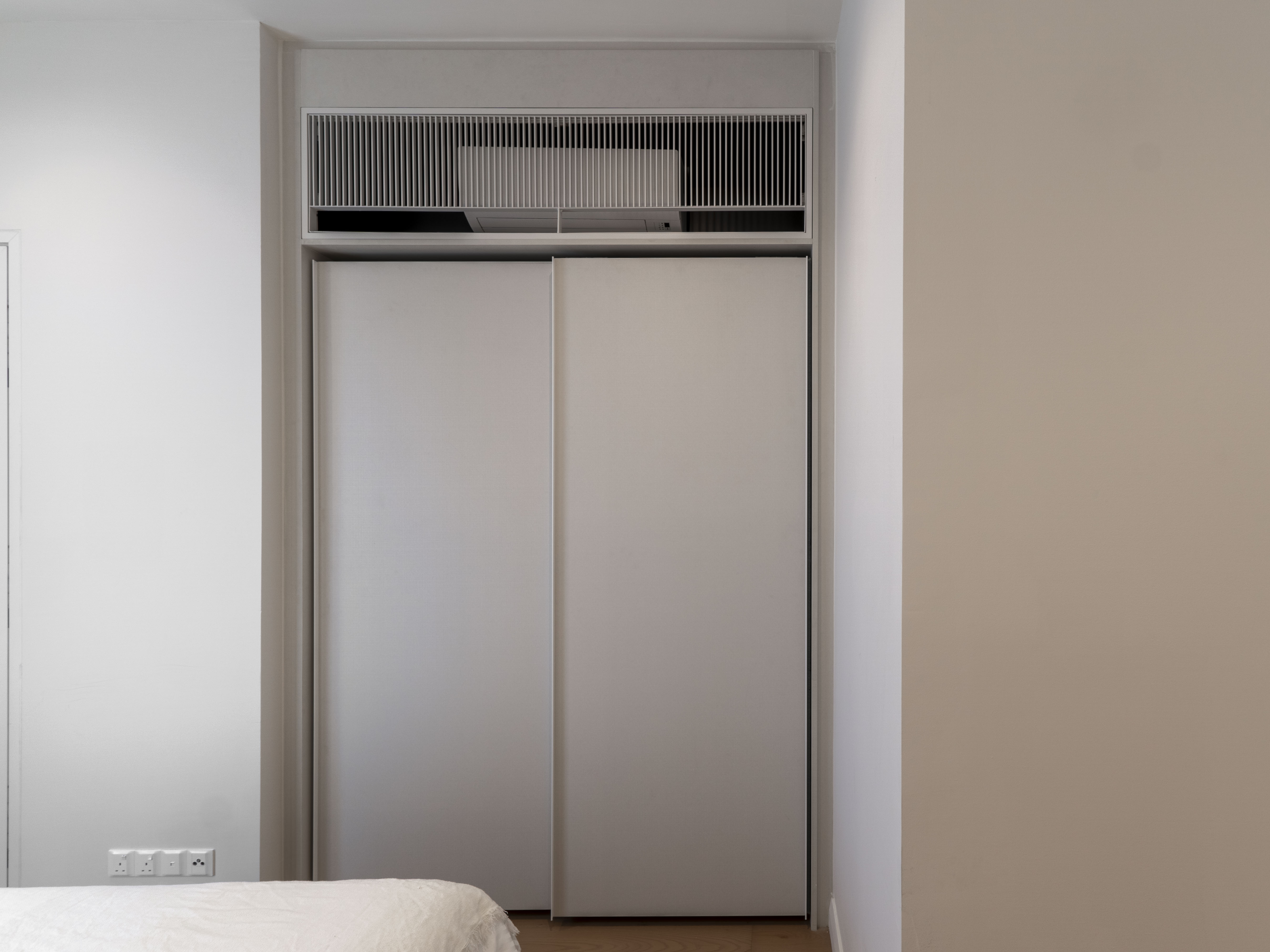 Built-in bedroom wardrobe beneath the air-conditioning grille at TRX Residence, Unit 01