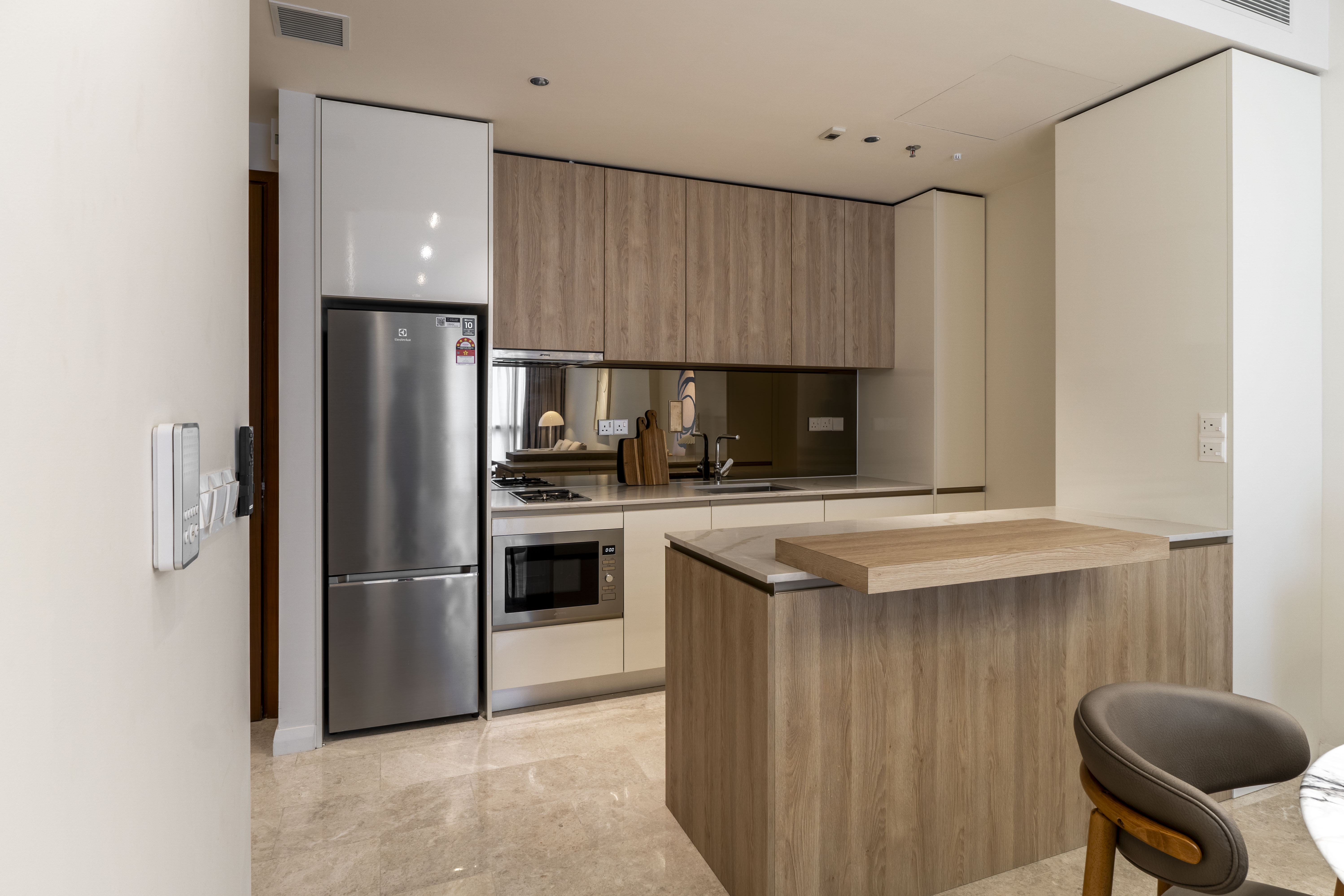 Timber kitchen cabinetry with breakfast counter and appliances at TRX Residence, Unit 01