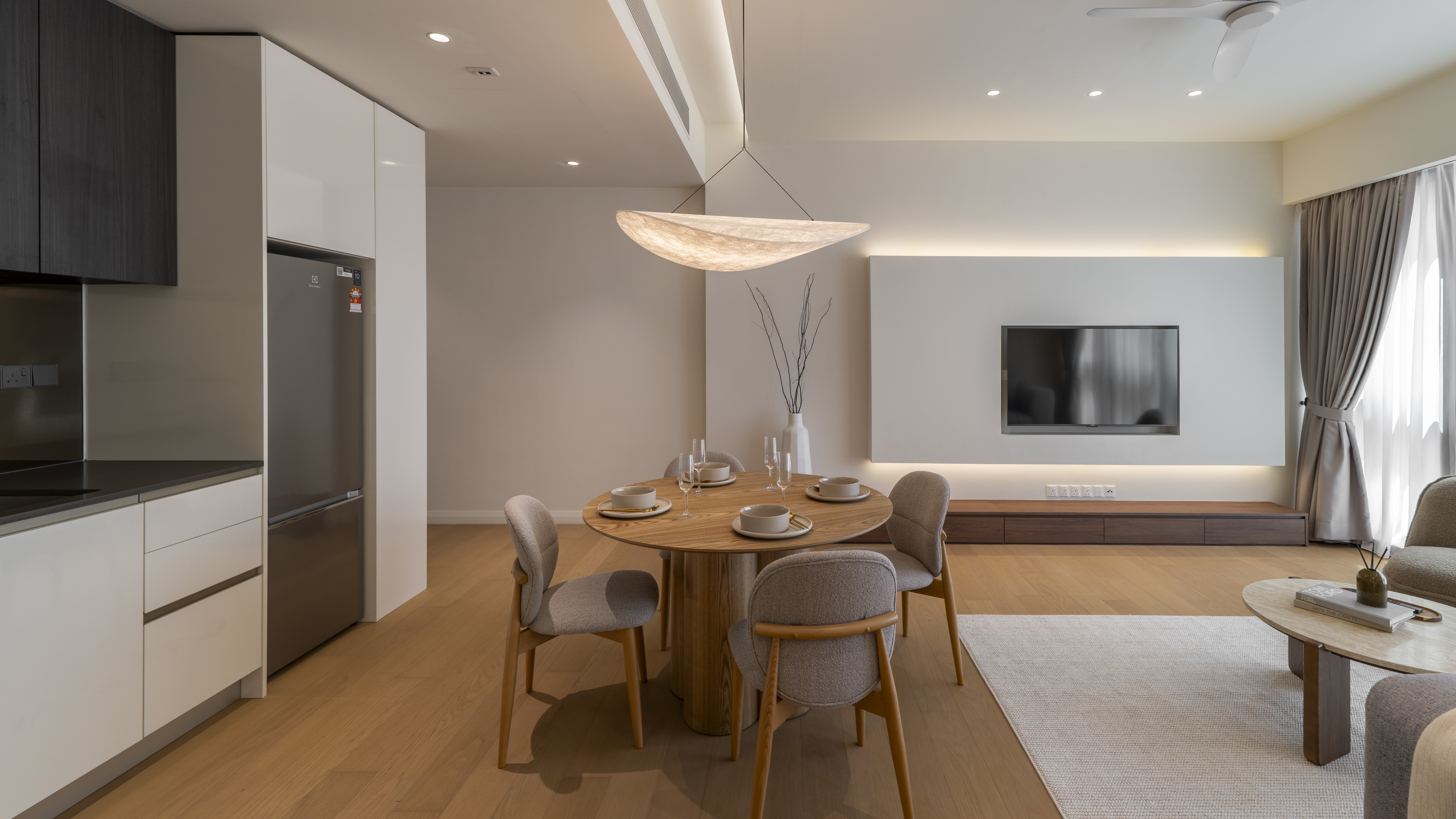 Round dining table facing the television wall at TRX Residence, Unit 02