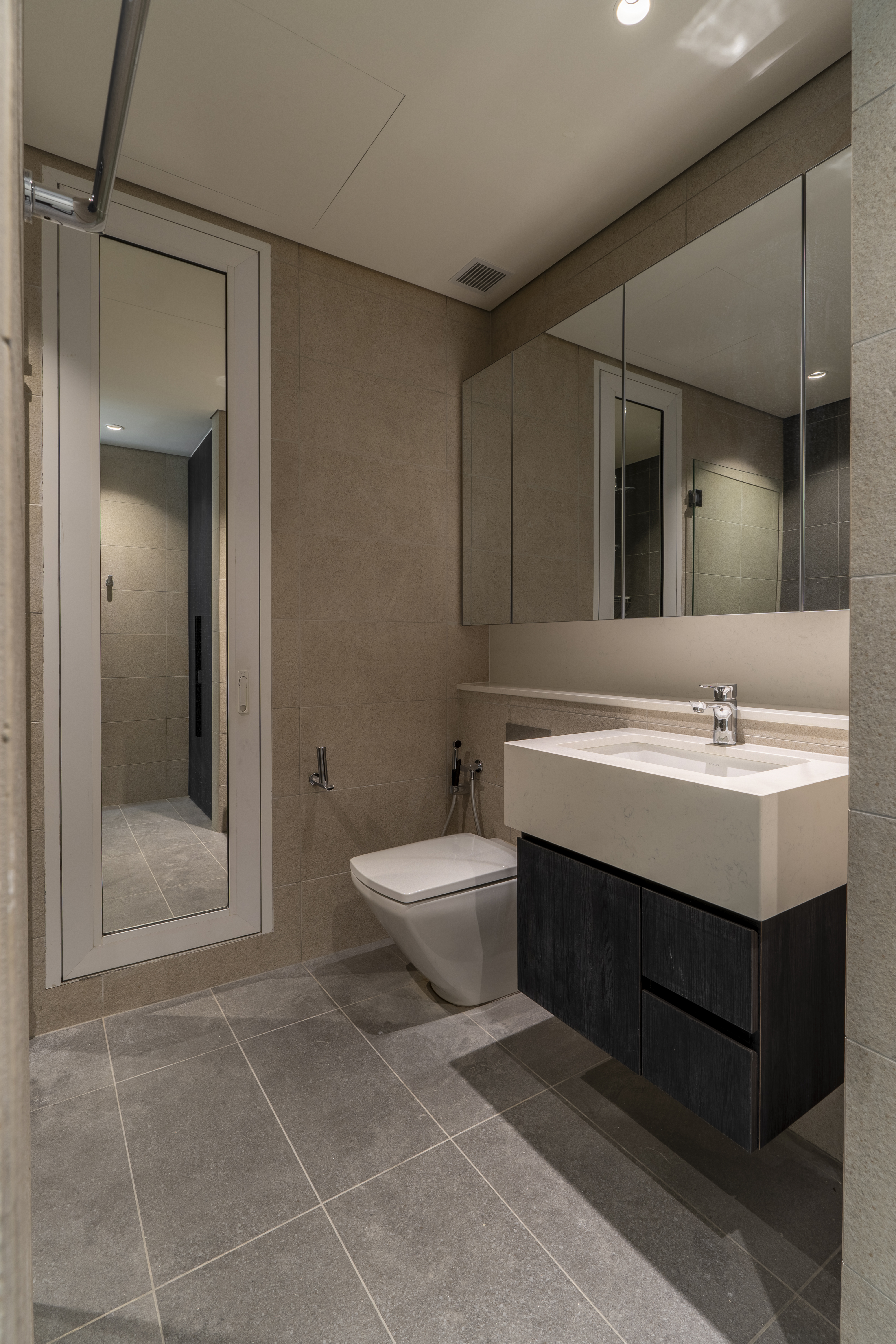 Bathroom with floating vanity and mirrored storage at TRX Residence, Unit 02