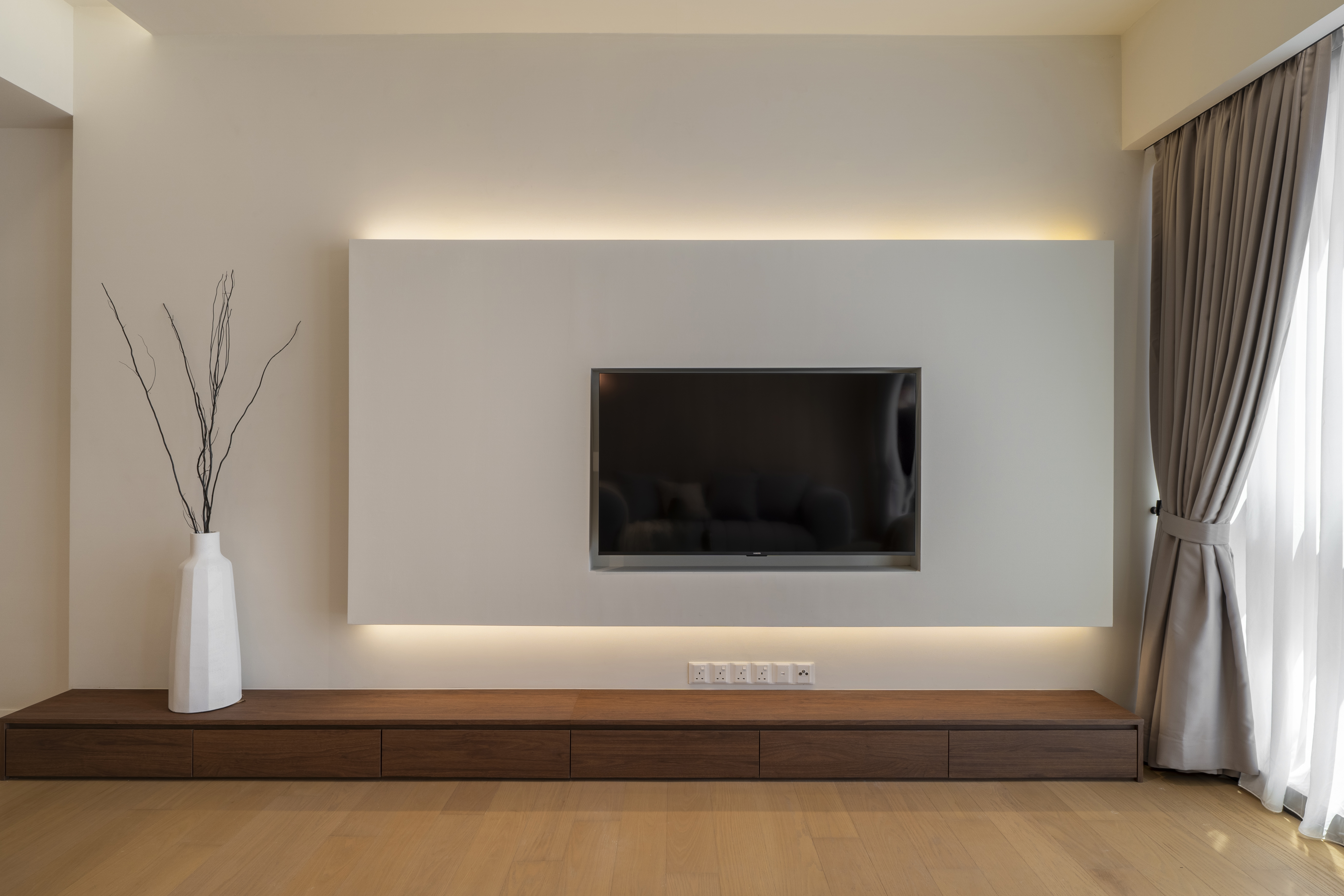 Backlit television wall above a low timber console at TRX Residence, Unit 02