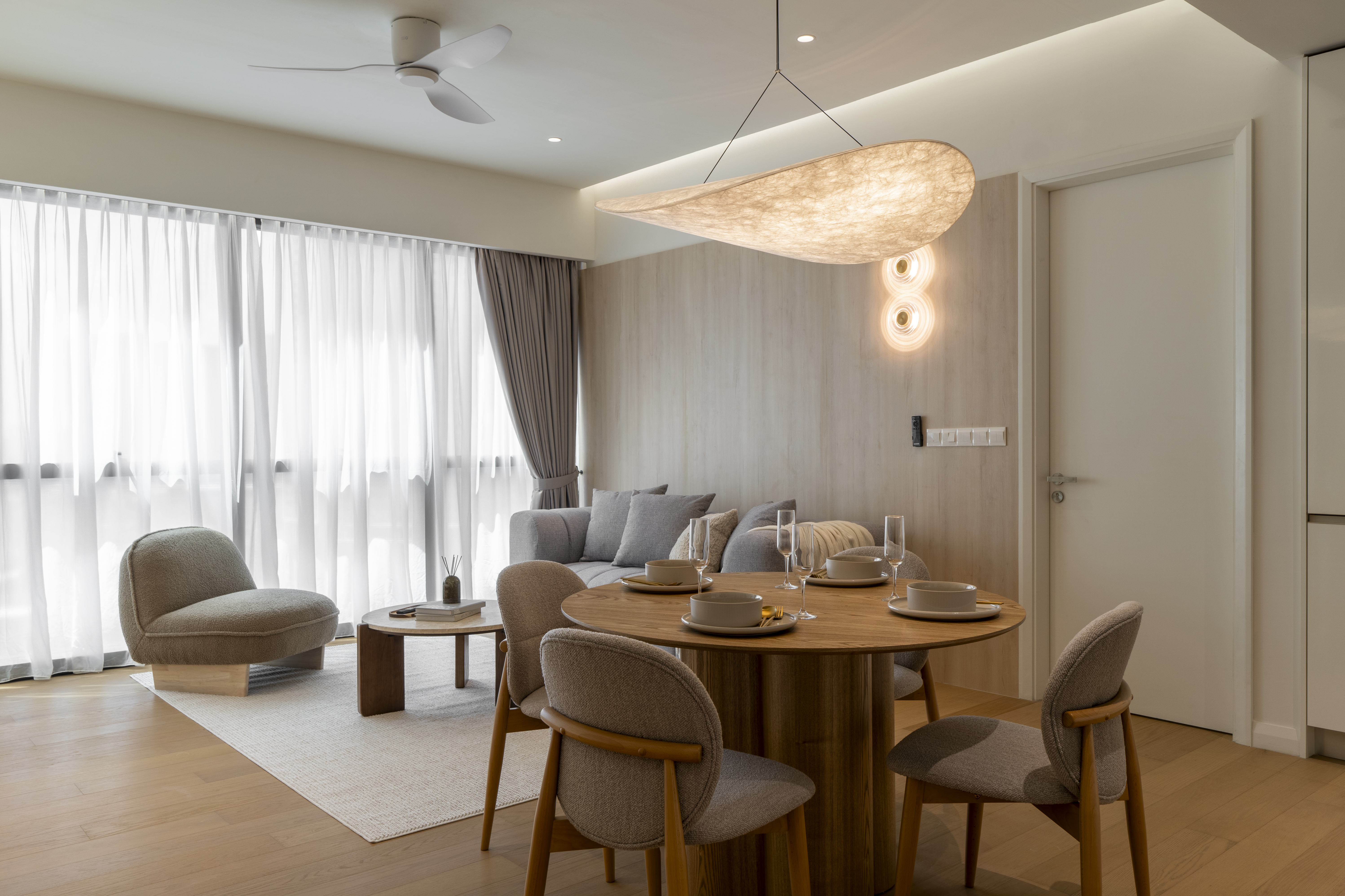 Dining and lounge area beside full-height curtains at TRX Residence, Unit 02