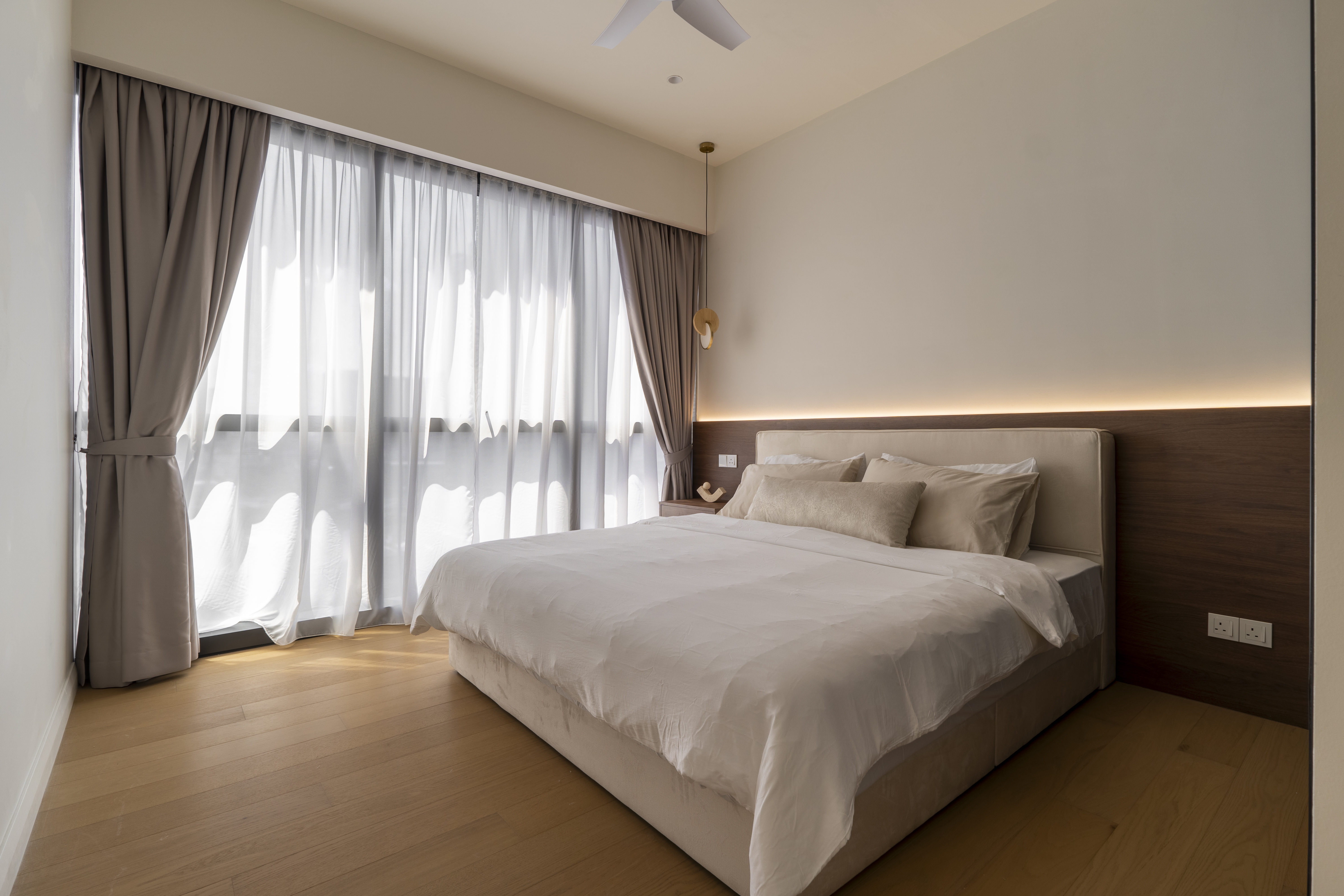 Bedroom with sheer curtains and warm headboard lighting at TRX Residence, Unit 02
