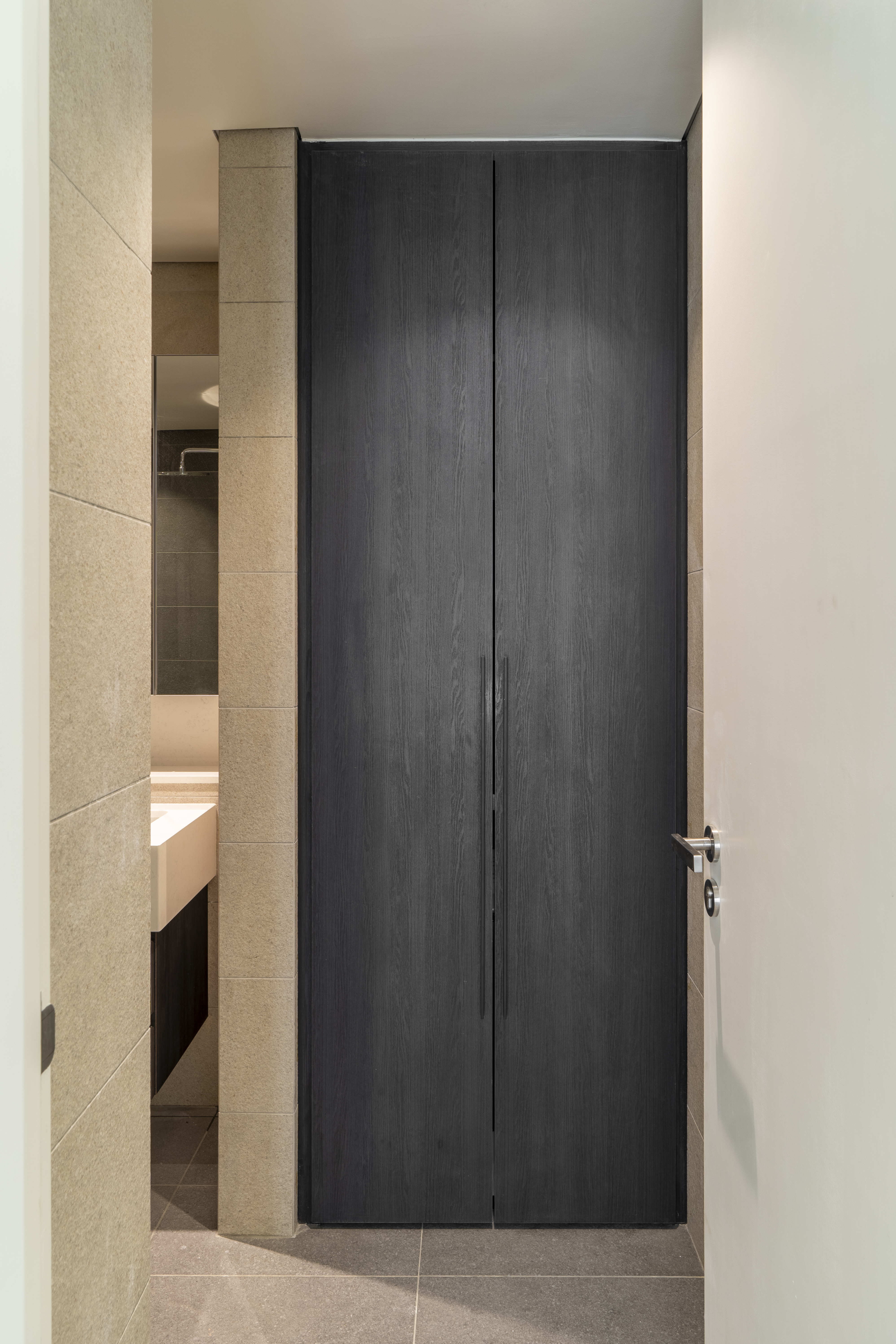 Dark bathroom door beside a mirrored vanity at TRX Residence, Unit 02