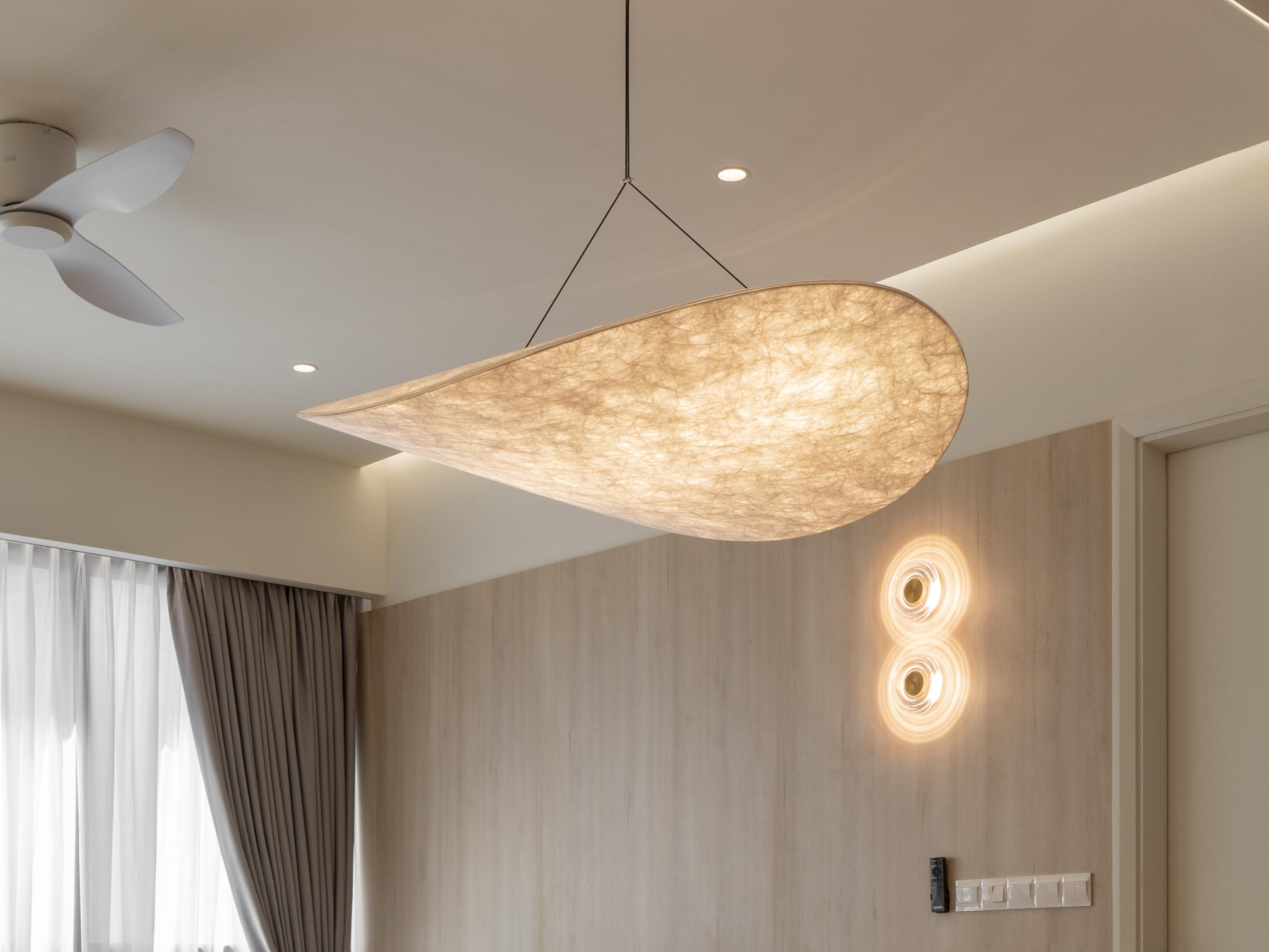 Sculptural pendant and decorative wall lights in the living area at TRX Residence, Unit 02