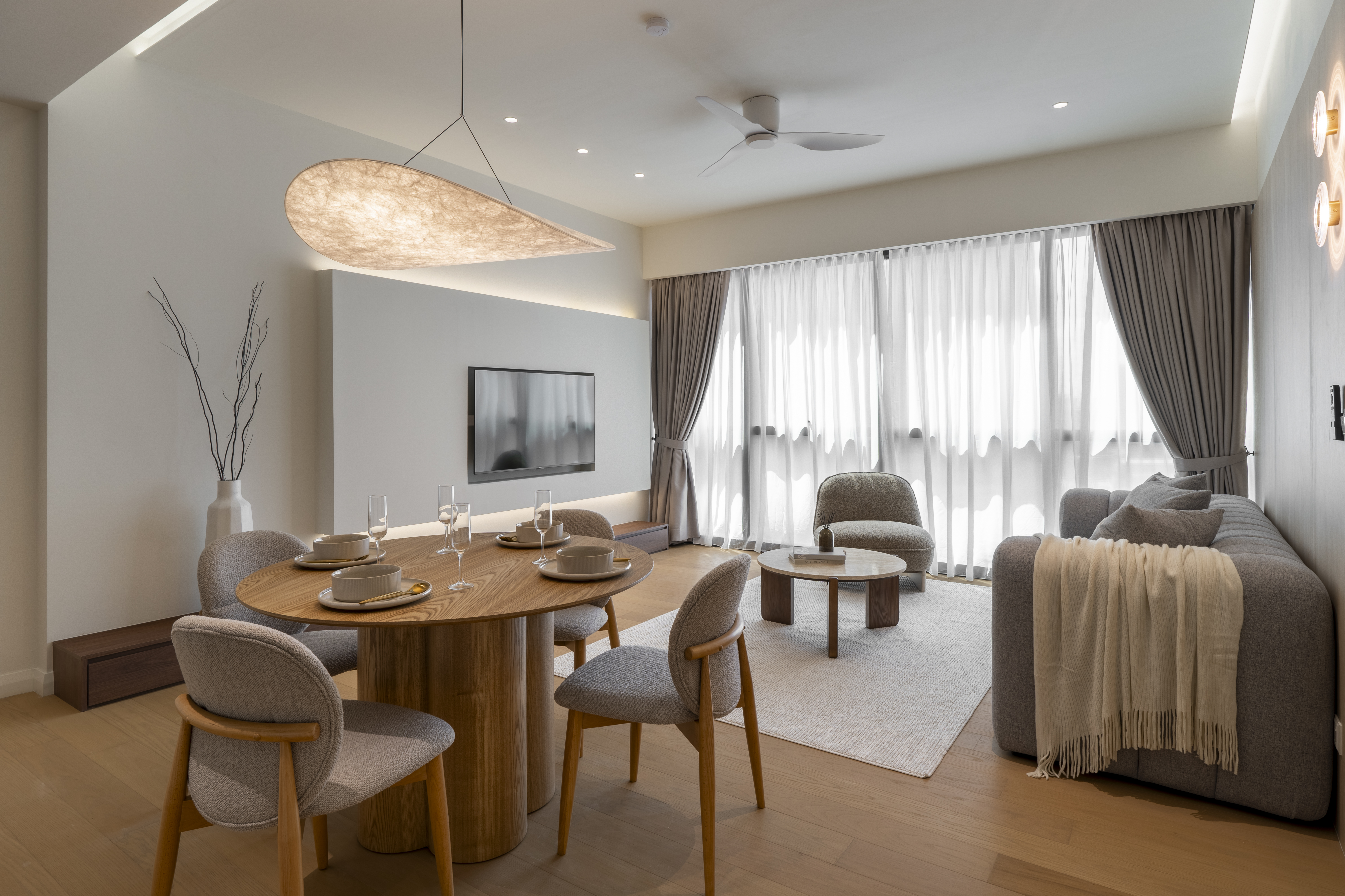 Round dining table looking towards the lounge and curtains at TRX Residence, Unit 02