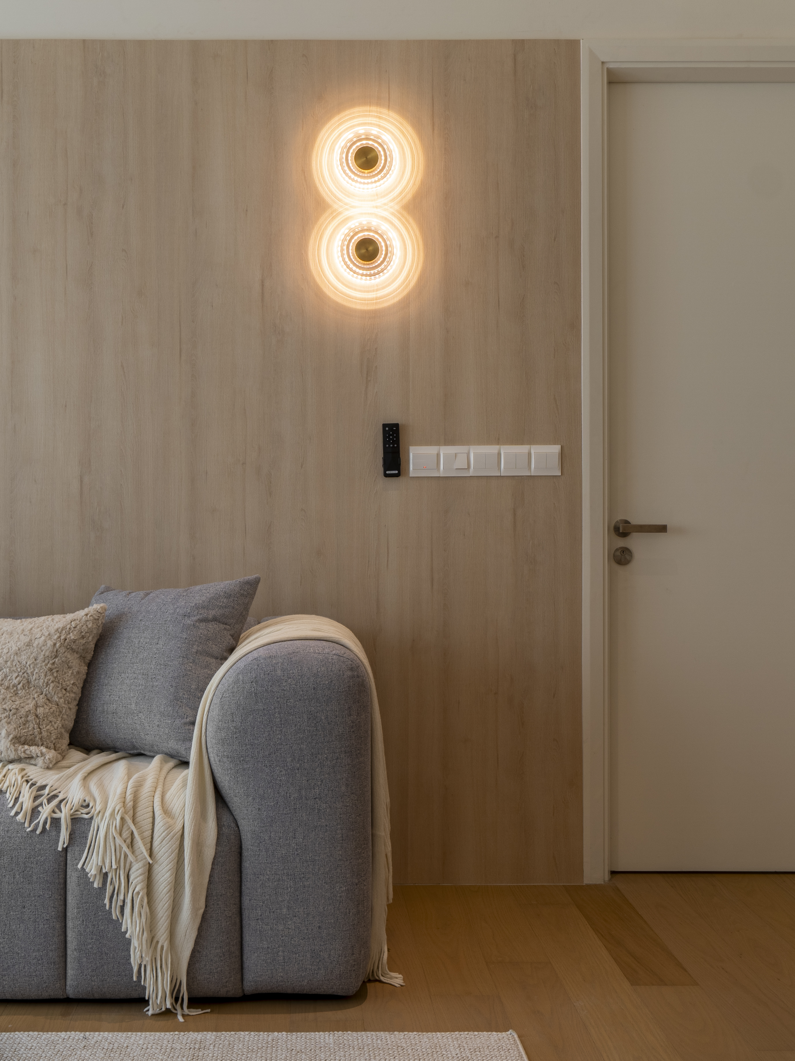 Decorative wall lights above the sofa on a timber feature wall at TRX Residence, Unit 02