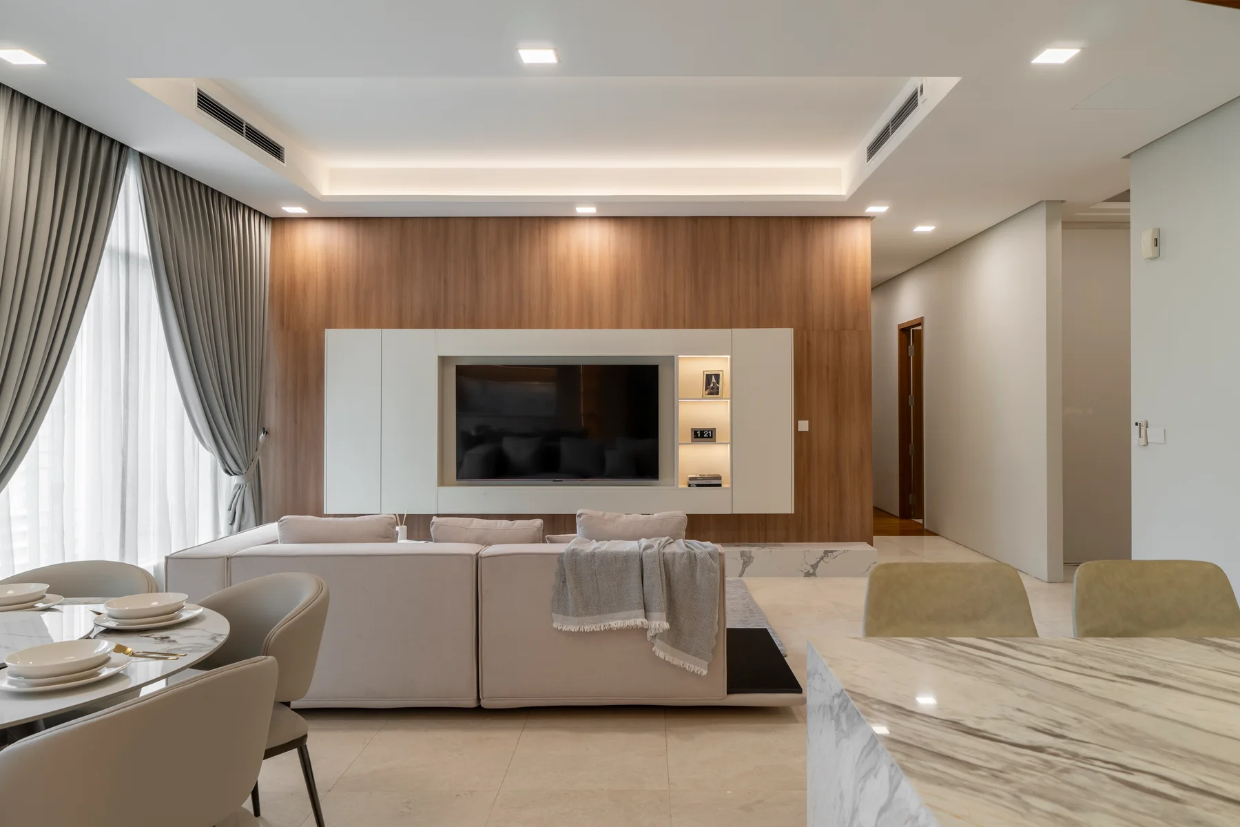 The completed living room with its timber TV feature wall, illuminated display and neutral sofa