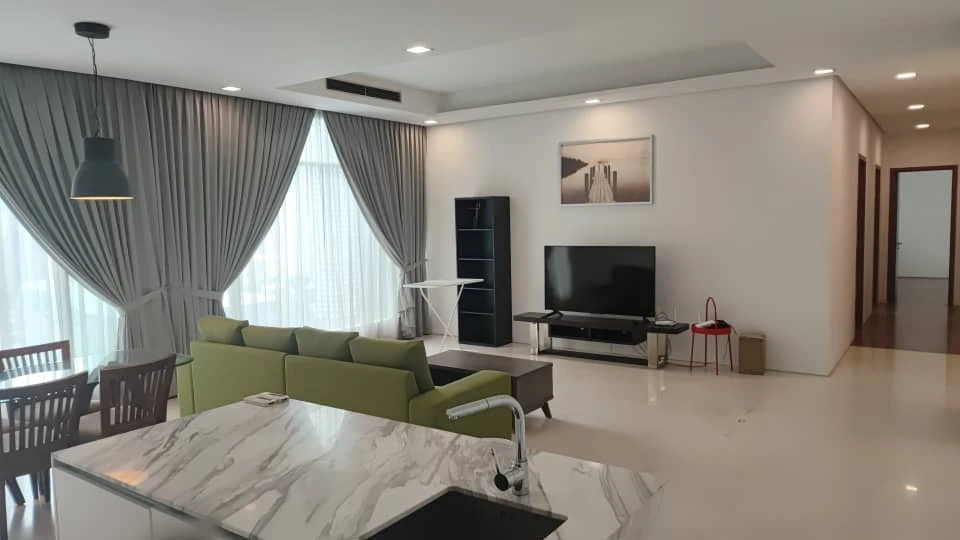 Before: the same Quadro living area with a plain TV wall, freestanding shelving and green sofa